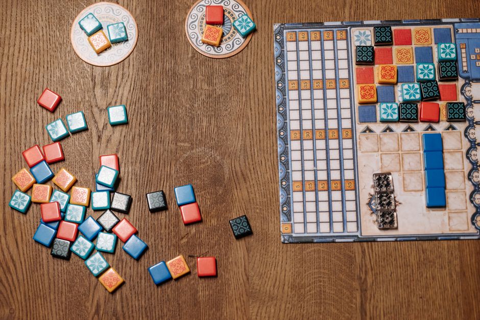 Board game pieces and tiles being sorted during setup