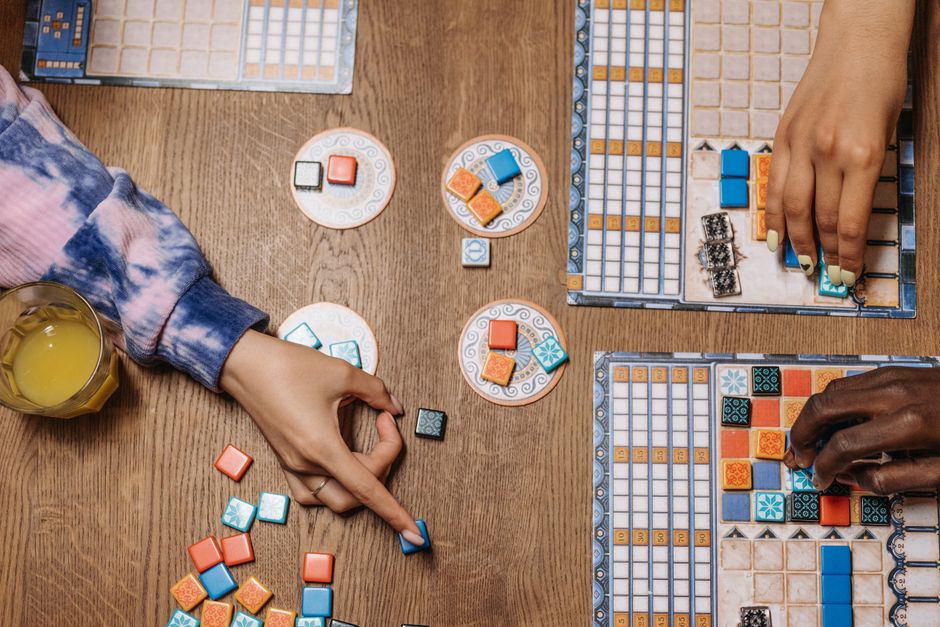 Players working together on a cooperative board game