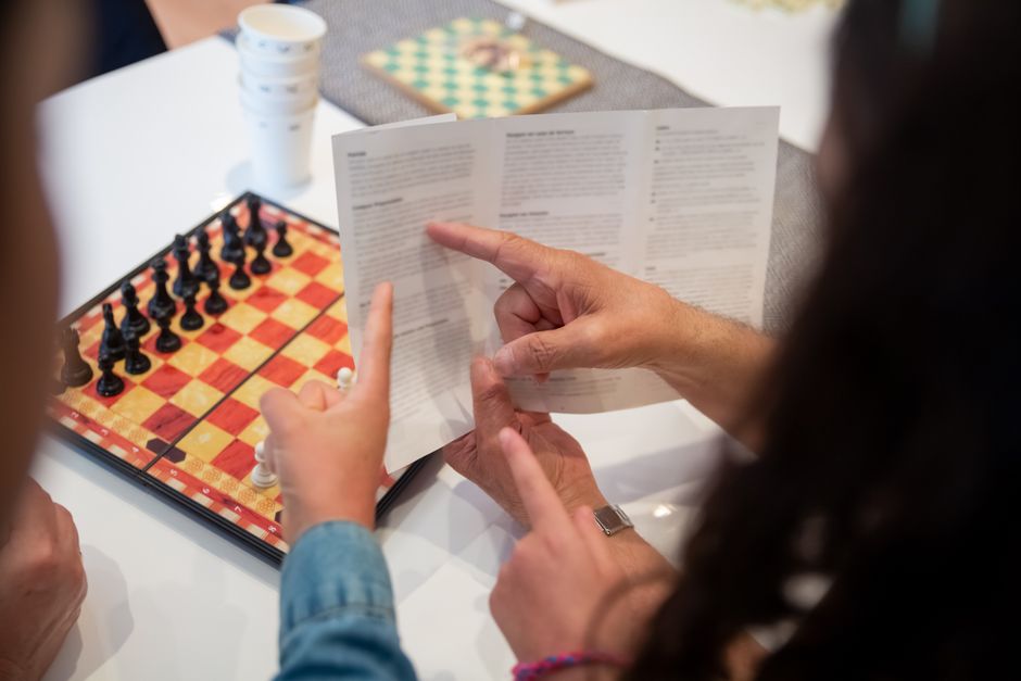 A player explaining board game rules to friends at a table